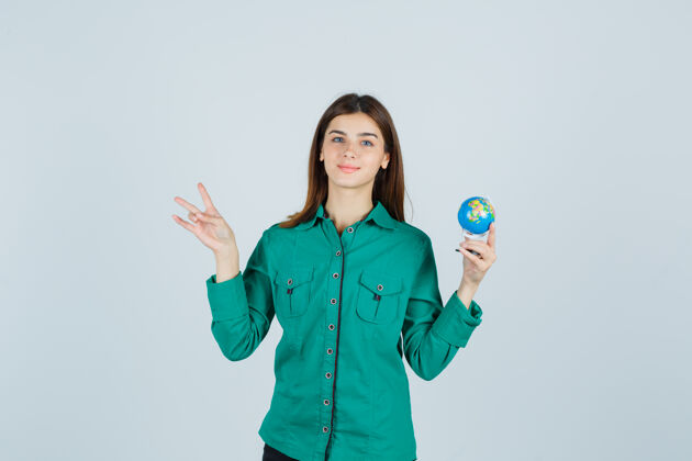 休闲年轻的女士拿着地球仪 展示着穿衬衫的十号 看上去很高兴 正前方牙齿显示前面
