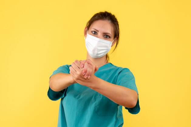 女医生正面图黄色背景上穿着无菌口罩医用衬衫的女医生医生人肖像