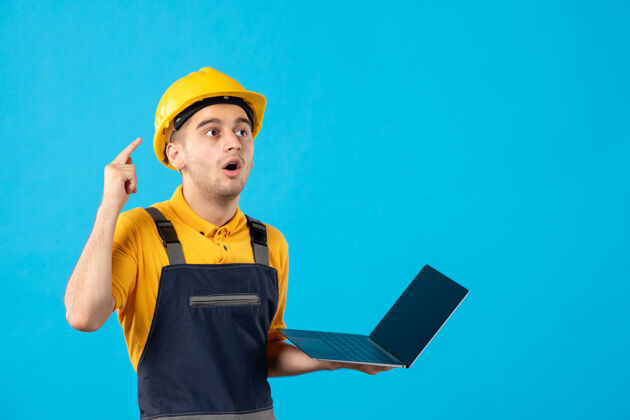 工程师穿着制服的男工人的正视图 蓝色笔记本电脑工作建筑工人制服