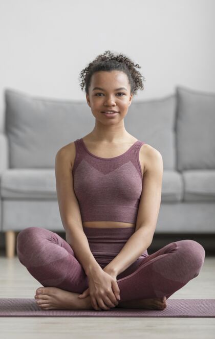 企业健身女士在家里用瑜伽垫做瑜伽和平锻炼健康