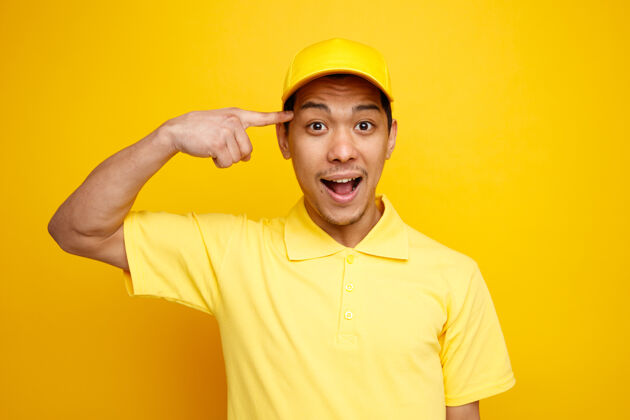 黄色兴奋的年轻送货员戴着帽子和制服做着思考的手势男人兴奋制服