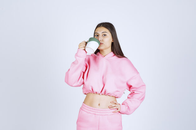员工穿着粉色睡衣的女孩拿着咖啡杯喝着咖啡服装冬天聪明