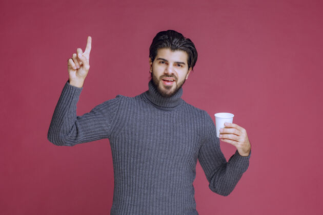 成人男人拿着一个一次性咖啡杯 感觉充满力量和活力姿势人促销