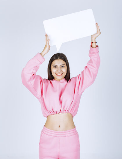 娱乐穿着粉色睡衣的女孩头上举着一个空白的长方形盒子在思考促销人体模型头脑风暴