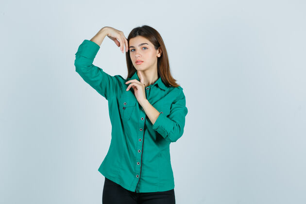 眼睛年轻的女性 手抱着头 穿着绿色衬衫 看起来很精致前视图姿势模特成人