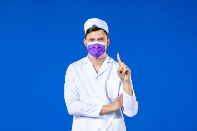 实验服身穿医疗服 戴着紫色面罩的男医生的正视图 蓝色的西装药品病毒