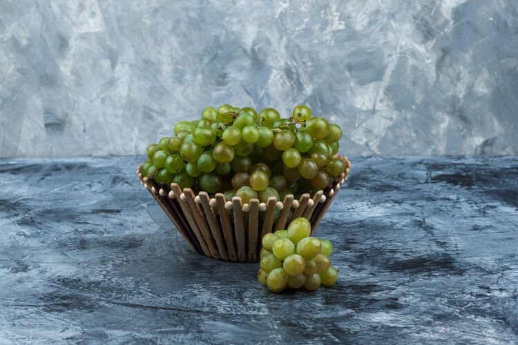 果汁一些绿色的葡萄在一个肮脏的石膏背景 侧视图篮子饮食秋天水果