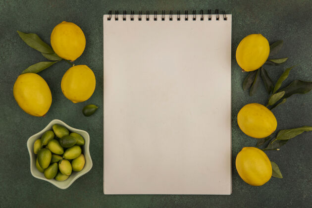 美味新鲜金盏花的顶视图与柠檬隔离在一个绿色的表面与复制空间碗碗食物饮食