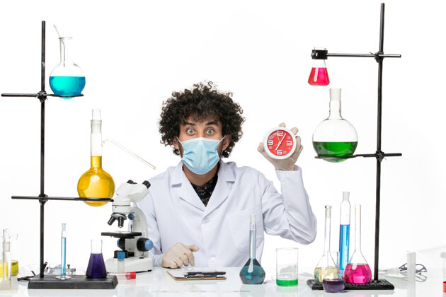 实验室外套正面图：男化学家穿着医疗服 戴着面具 在空白处拿着时钟手持男性医学