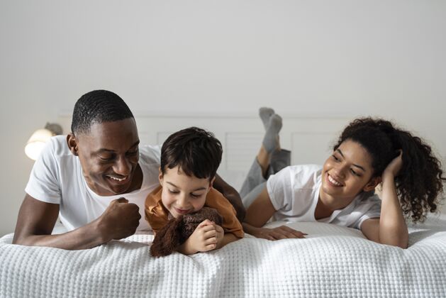 熟悉躺在床上幸福的黑人家庭玩耍质量时间快乐的人