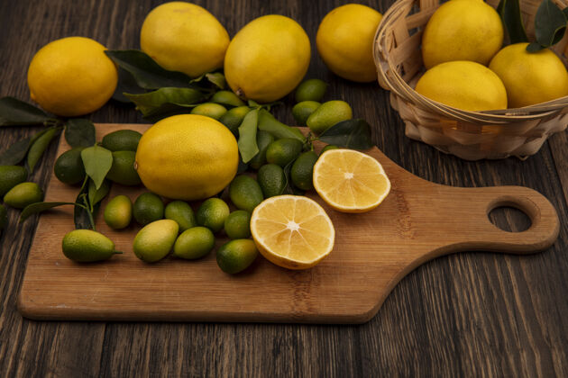 桶黄色柠檬桶的俯视图 木制厨房板上有柠檬和金盏花新鲜美味柑橘