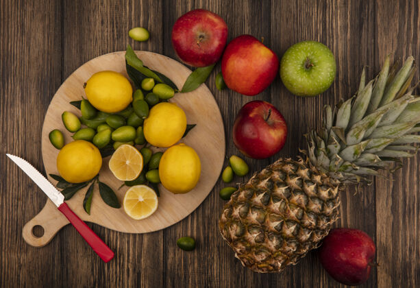 饮食新鲜柠檬的俯视图与苹果和菠萝隔离在木制的厨房板上新鲜切片柠檬