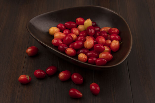 配料木制表面上的棕色碗上的酸的新鲜的山茱萸樱桃的俯视图美味饮食营养