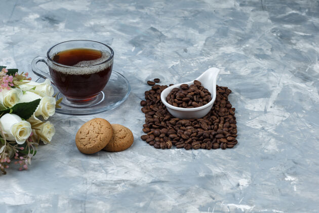 曲奇把咖啡豆放在白瓷壶里 放上饼干 咖啡杯 鲜花咖啡馆烤食物