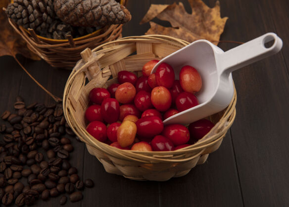 松木桶上的淡红色小凤梨果实的俯视图 桶上有松果 桶上有金黄色的叶子 咖啡豆孤立在木制表面上食物树叶苍白