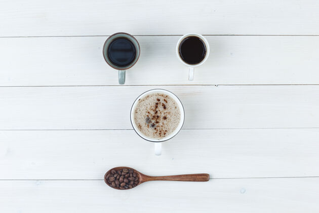 勺子带咖啡豆的杯子里的咖啡木制背景上的顶视图香味质地热的