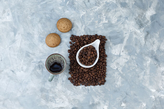 粗麻布顶视图咖啡豆在白色瓷罐饼干 咖啡杯蓝色大理石背景水平拿铁新鲜的自然