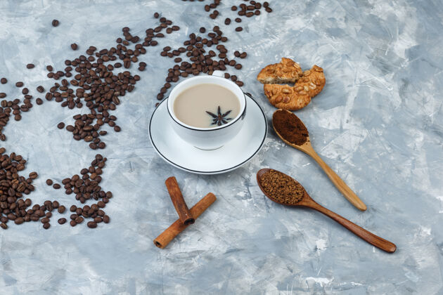高一套饼干 咖啡豆 磨碎的咖啡 肉桂棒和咖啡在一个灰色的石膏背景杯高角度视图套装乡村的质地