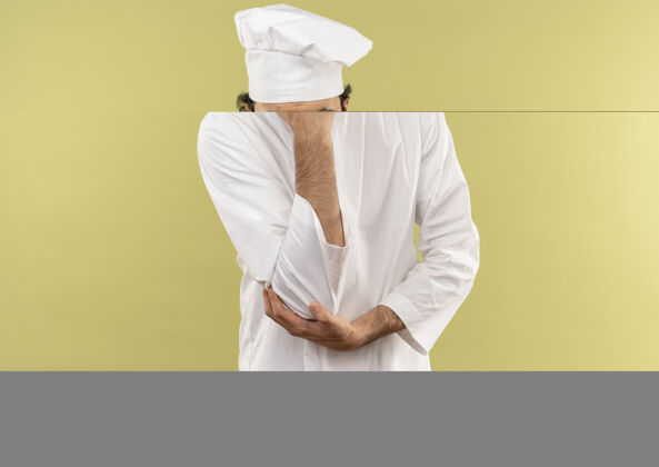 年轻自信的年轻男厨师穿着厨师制服 戴着眼镜 手放在下巴上厨师绿制服