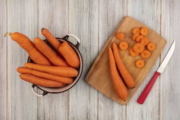 胡萝卜顶视图新鲜的橙色胡萝卜在一个木制的厨房板与刀胡萝卜在一个灰色的木制表面碗碗美味板