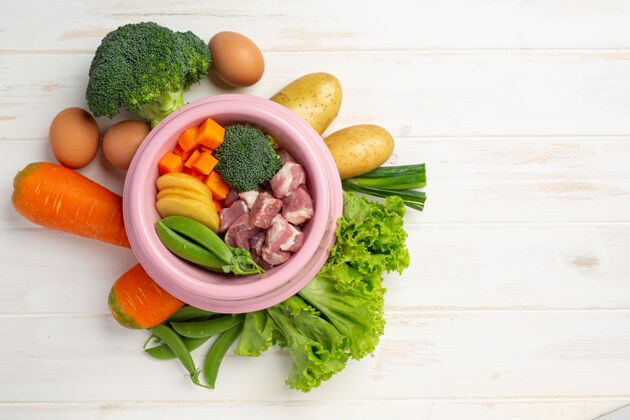堆健康新鲜的宠物食品配料在白色木质表面膳食蛋白质胡萝卜