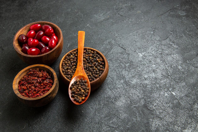 配料前视图新鲜的红色山茱萸与调味品的灰色空间木勺热的浆果