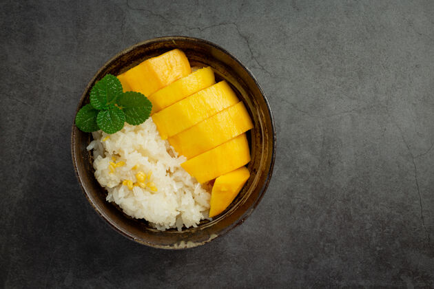 热带新鲜成熟的芒果和糯米 在黑暗的表面涂上椰子奶特写水果食物