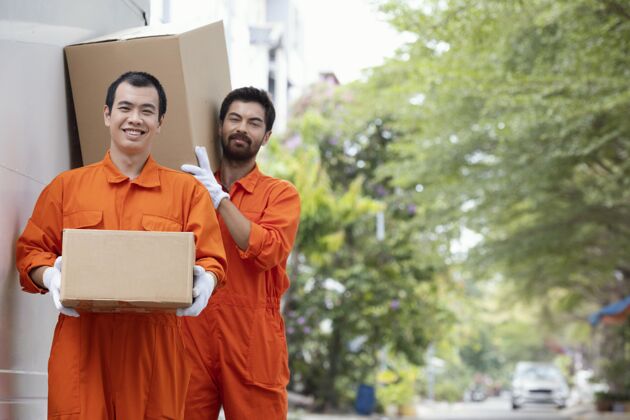 商务年轻的送货员在搬运包裹箱搬运邮件快乐