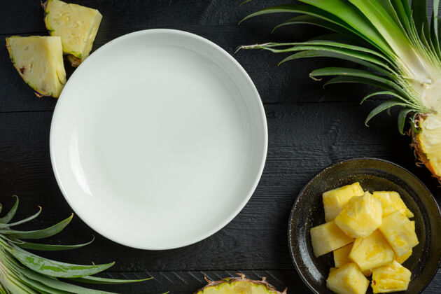 黄色新鲜的菠萝放在深色的木头表面餐桌水平蔬菜