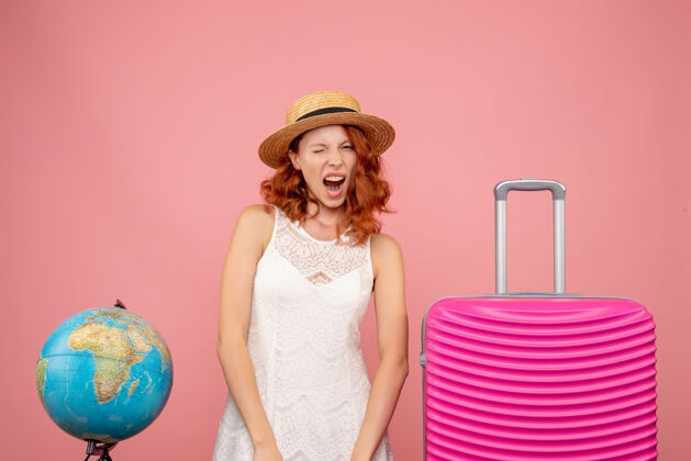 成人年轻女性游客的正面图 粉红色的墙上挂着粉红色的包夏天肖像旅行