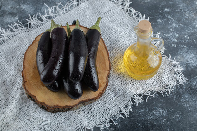 早餐新鲜的紫色茄子放在木板上 还有一瓶油顶视图健康餐桌自然
