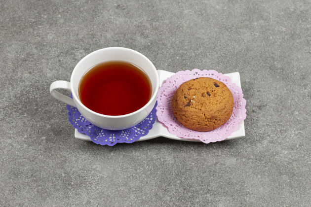 美味在白碟子上放一杯茶和饼干糕点饼干美食