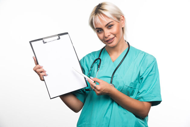 工作面带微笑的女医生用白纸笔指着剪贴板制服女性成人