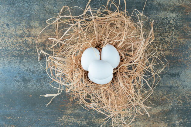 食物鸡新鲜的白色鸡蛋躺在干草大理石背景白自然蛋壳