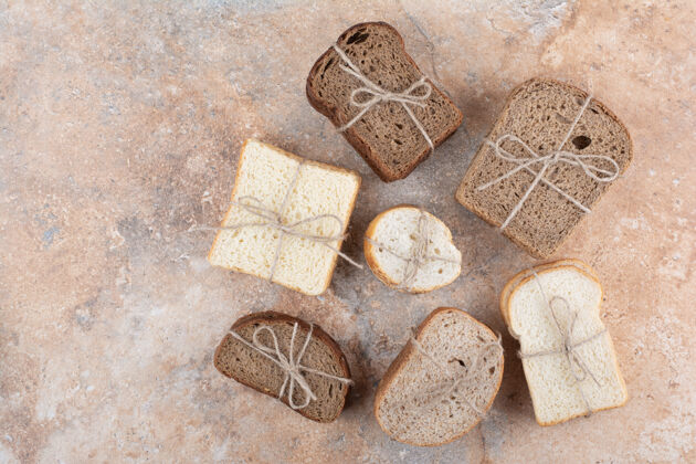 面包房大理石背景上的各种面包堆面包绳索食品