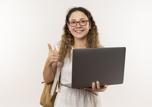 包快乐的年轻漂亮的女学生戴着眼镜 背着包拿着笔记本电脑 大拇指朝上 与复印空间隔离漂亮向上女学生