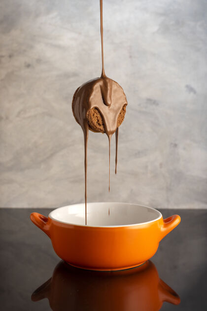 糖垂直拍摄的美味饼干被巧克力覆盖在一个橙色的碗甜点面包房碗