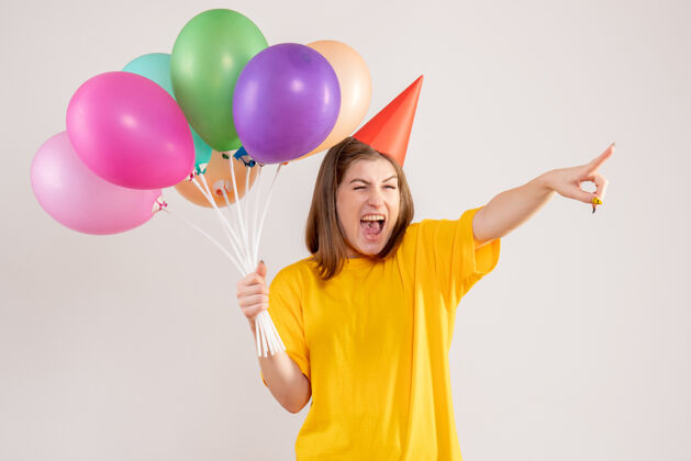 气球手持白色气球的年轻女子吹生日聚会