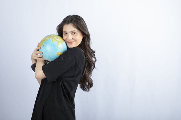 青少年黑发女人拿着地球仪摆姿势世界情感时尚