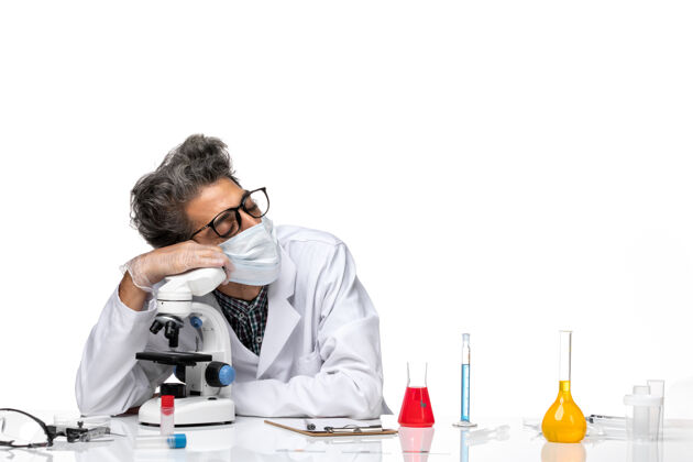 人正面图穿着白色医疗服的中年科学家坐在显微镜下睡觉视图显微镜医学