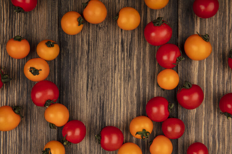 有机顶视图的有机红色和橙色樱桃番茄隔离在一个木制的墙壁与复制空间新鲜木材农业