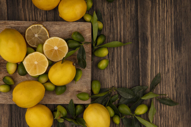 厨房新鲜水果的俯视图 比如金盏花和柠檬 它们被隔离在木质厨房板上 木质墙壁上有复制空间顶部景观膳食