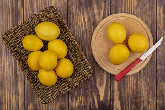 水果柳条托盘上的健康柠檬俯视图 柠檬被隔离在木制厨房板上 刀放在木制墙上柳条木头板