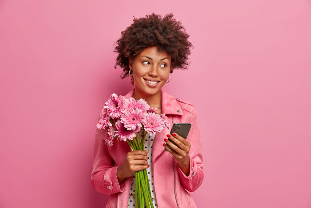 节日时尚快乐女花店摆出非洲菊花束和智能手机人沟通情感