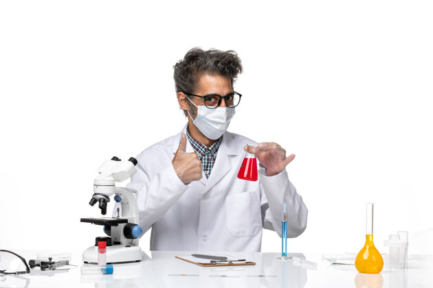 实验室外套正面图穿着特殊套装的中年科学家坐着拿着装有红色溶液的烧瓶观点化学技师
