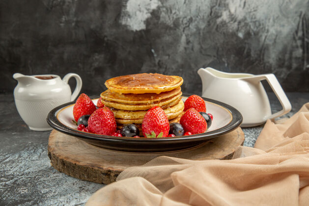 草莓正面是美味的薄饼 上面有水果和蜂蜜 表面是甜的水果奶牛奶早餐美味
