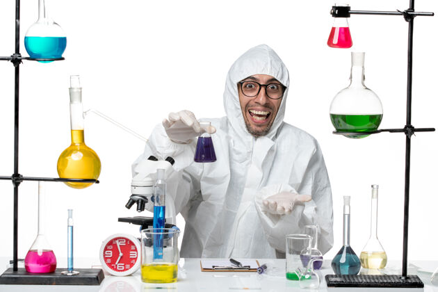 研究正面图穿着特殊防护服的男科学家拿着装有紫色溶液的烧瓶实验室科学烧瓶