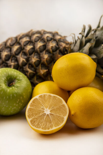素食侧视图的水果 如菠萝绿苹果和柠檬隔离在一个白色的墙壁人农业人