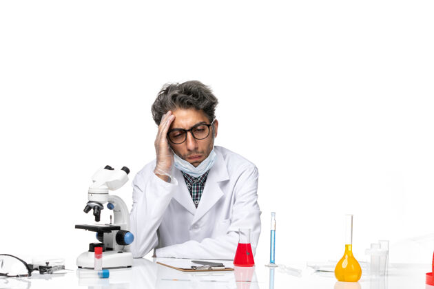 坐正面图穿着特殊白色西装的中年科学家围坐在桌子旁 拿着解决方案实验室外套解决方案男性
