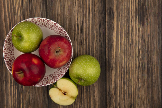 水果一个碗上新鲜多彩的苹果的俯视图 绿色的苹果被隔离在有复制空间的木墙上彩色特写农业